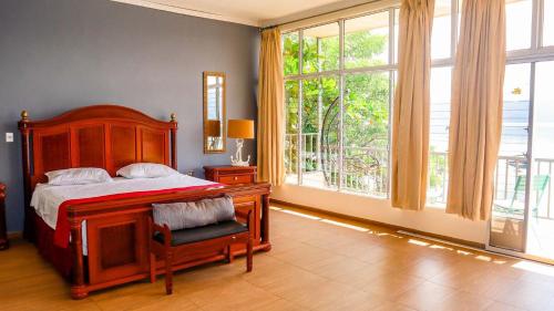 um quarto com uma cama e uma grande janela em Quinta Sunset, Lago de Coatepeque em El Congo
