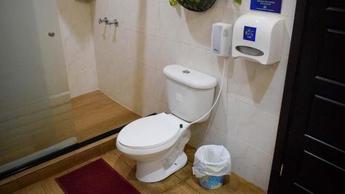 a bathroom with a toilet and a phone on the wall at Quinta Sunset, Lago de Coatepeque in El Congo