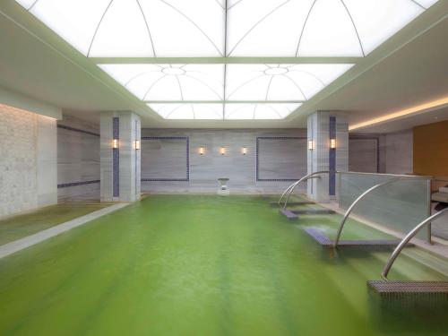 a large room with a pool of green water at Mövenpick Hotel & Thermal Spa Bursa in Bursa