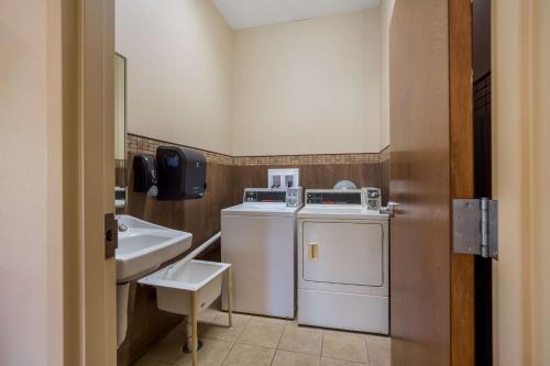 a bathroom with a washer and dryer and a sink at SureStay Hotel by Best Western Whittington Rend Lake in Whittington