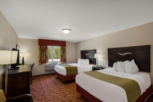 a hotel room with two beds and a television at SureStay Hotel by Best Western Whittington Rend Lake in Whittington