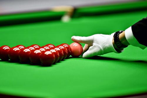 a person in white gloves holding a balls on a pool table at Radisson Golf Resort Pahalgam in Pahalgām