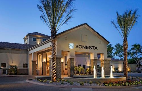 un hôtel avec des palmiers devant un bâtiment dans l'établissement Sonesta Suites Scottsdale Gainey Ranch, à Scottsdale