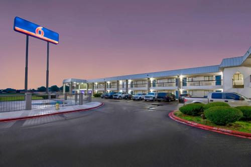 a hotel with cars parked in a parking lot at Motel 6 Texarkana, TX in Texarkana - Texas