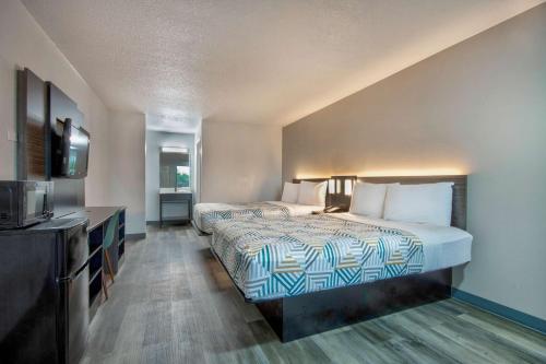 a hotel room with two beds and a television at Motel 6 Texarkana, TX in Texarkana - Texas