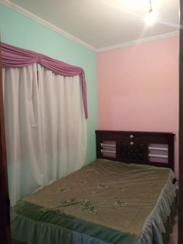 a bedroom with a bed with a curtain and a window at Pousada Recanto da Villa in Mucugê