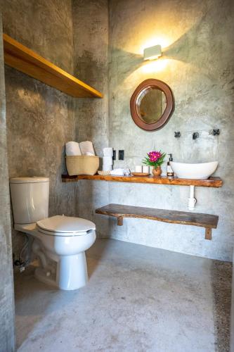 a bathroom with a toilet and a sink and a mirror at Casa Monika Vista Suit in Puerto Escondido