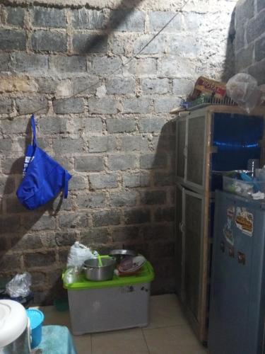 una cucina con muro di mattoni e frigorifero di Bellzan Home Stay BZ a Cimandala