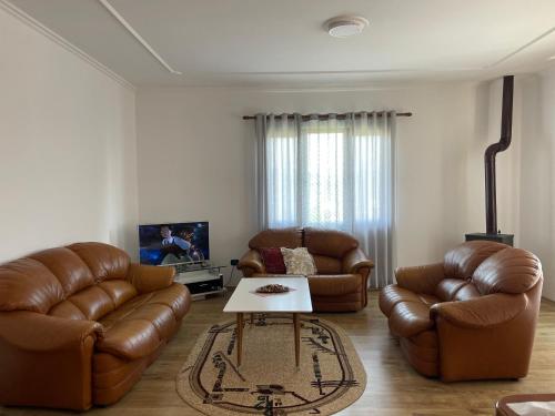 ein Wohnzimmer mit 2 Ledersofas und einem Couchtisch in der Unterkunft Ajla’s home in Vorë