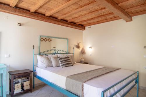 ein Schlafzimmer mit einem Bett und einer Holzdecke in der Unterkunft Villa Theodora View Apartments Thalia in Agios Georgios Pagon