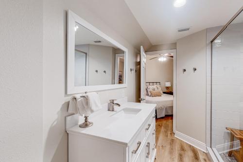 a white bathroom with a sink and a mirror at Renovar at The Club in Mexico Beach