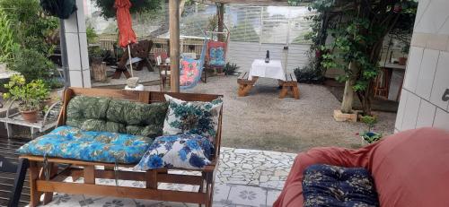 a patio with a couch and pillows on it at Pousada Mar Aberto Pinheira in Pinheira