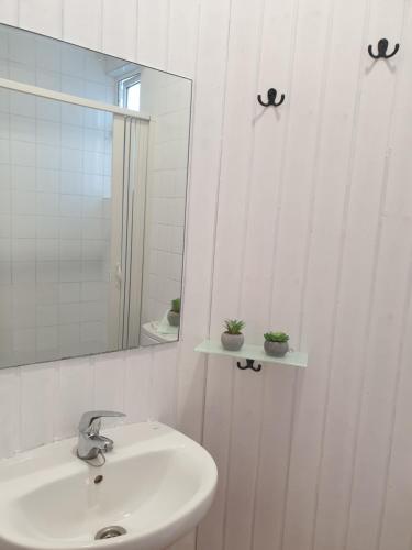 Baño blanco con lavabo y espejo en Casita adosada, en Vigo
