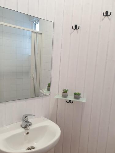 bagno bianco con lavandino e specchio di Casita adosada a Vigo