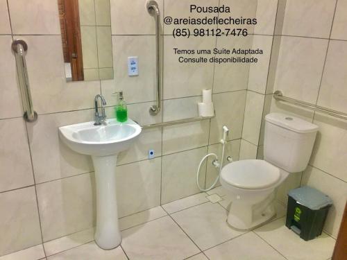 a bathroom with a white sink and a toilet at Pousada Areias de Flecheiras in Flecheiras