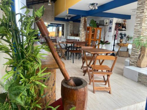 een restaurant met houten tafels en stoelen en een plant bij Pousada Maresias de Geribá in Búzios