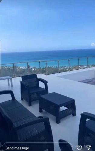 a group of chairs and tables on a balcony with the beach at Villa Ocean Blue in Las Terrenas