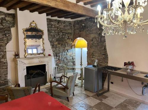 een woonkamer met een open haard en een kroonluchter bij La Piazzetta Toscana B&B in Campiglia Marittima