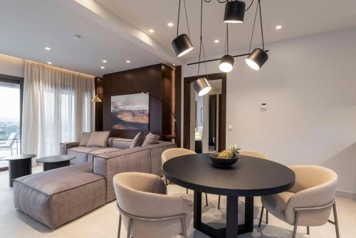 een woonkamer met een bank en een tafel en stoelen bij Maravilla Luxury Living in Kos-stad