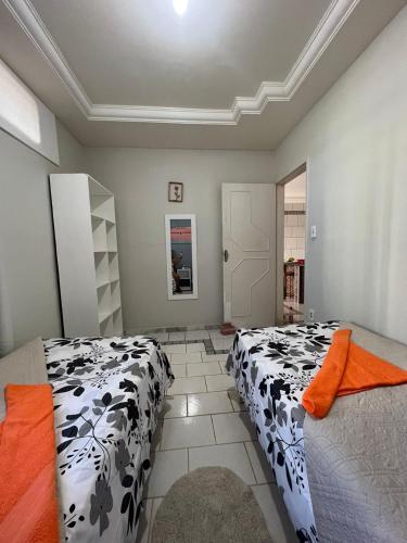 um quarto com 2 camas com lençóis brancos e pretos em Casa temporada Aracaju em Aracaju