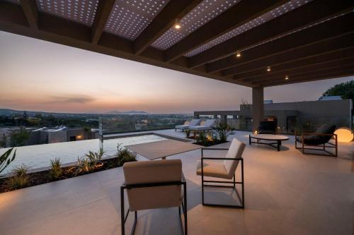 a patio with chairs and tables on a roof at Maravilla Luxury Living in Kos Town