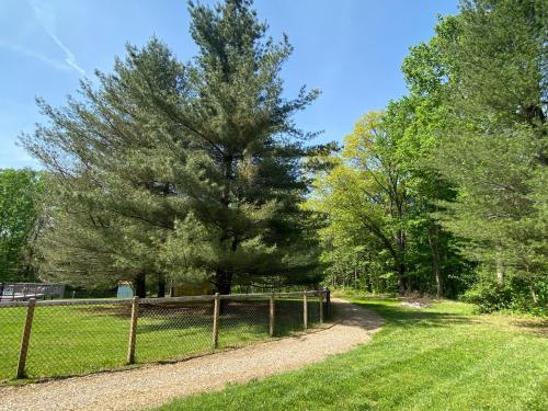 a fence next to a grass field with trees at The Chateau in Bloomington