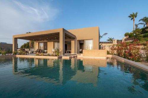a house with a swimming pool in front of it at Maravilla Luxury Living in Kos Town