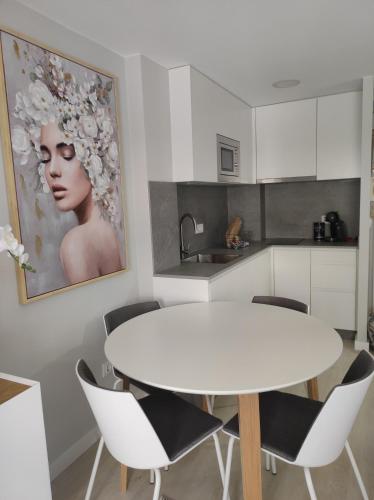 - une cuisine blanche avec une table et des chaises blanches dans l'établissement Céntrico estudio vialia, à Vigo