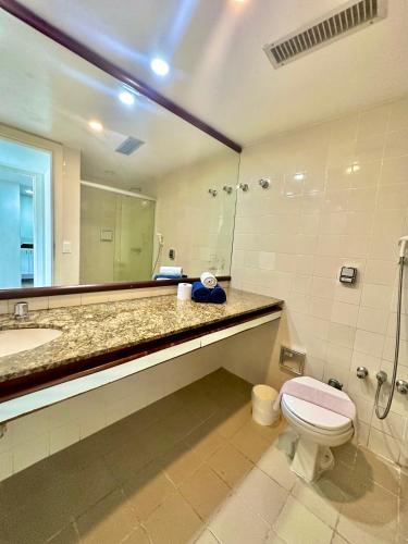a bathroom with a toilet and a sink and a mirror at Ondina Apart Hotel Residences in Salvador