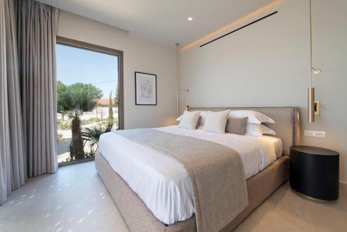 a bedroom with a large bed and a large window at Maravilla Luxury Living in Kos Town