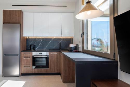a kitchen with a black counter top and a refrigerator at Maravilla Luxury Living in Kos Town