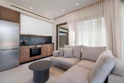 a living room with a couch and a kitchen at Maravilla Luxury Living in Kos Town