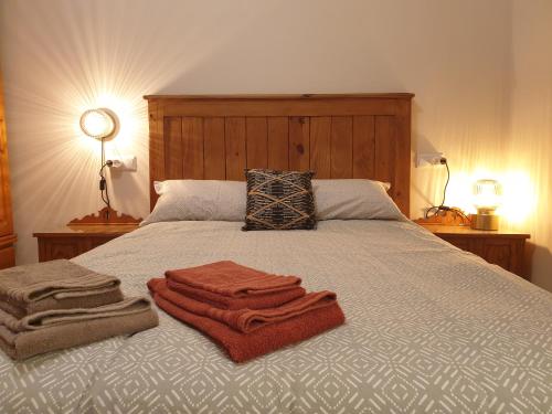 1 dormitorio con 1 cama con toallas en Casita adosada, en Vigo