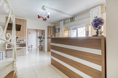 ein Wohnzimmer mit einer Treppe und eine Küche in der Unterkunft Hotel Pousada Vento Sul in Rio Grande