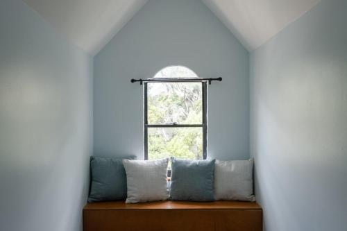 uma janela num quarto com um banco com almofadas em Spacious Family Friendly Retreat 3 BD Loft em Gainesville