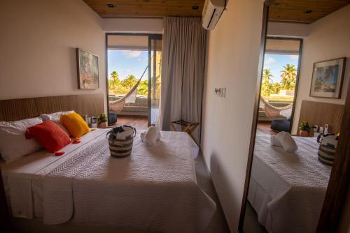 ein Schlafzimmer mit zwei Betten und einem Spiegel in der Unterkunft Milagres Hospedagens - Cobertura Rota 206 - Capela & Praia in São Miguel dos Milagres