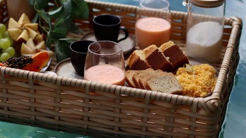 una cesta de comida con pan y fruta en una mesa en Milagres Hospedagens - Cobertura Rota 206 - Capela & Praia, en São Miguel dos Milagres