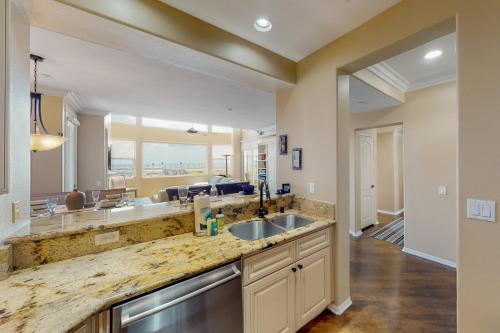 a large kitchen with a sink and a living room at Lagoon Sunrise 205 in Carlsbad