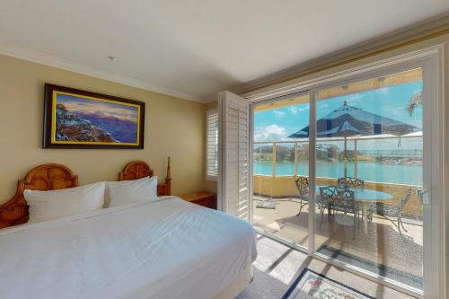 a bedroom with a bed and a balcony with a view at Lagoon Sunrise 205 in Carlsbad