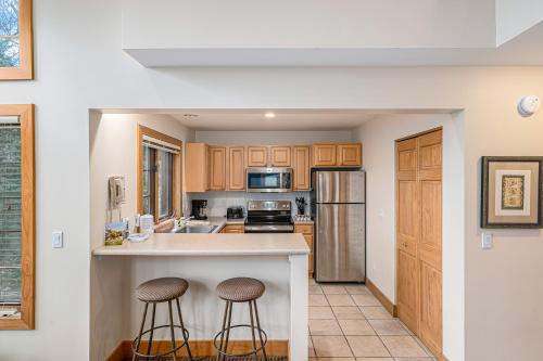 a kitchen with wooden cabinets and stainless steel appliances at Boyne Mountain Getaway, Unit A in Boyne Falls