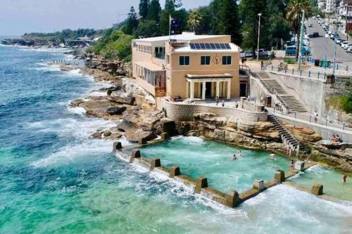 una piscina junto al océano con una casa en Ocean view en Sídney