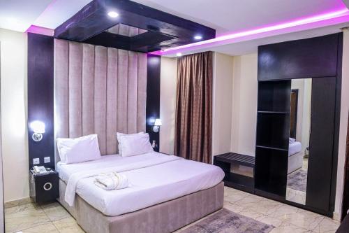 a bedroom with a large bed and a bath tub at THE HOUSE ABUJA in Abuja