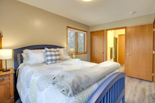 a bedroom with a blue bed and a window at Private Lakefront Retreat with Hot Tub, Deck and Views in Spicer
