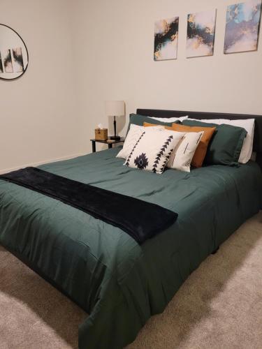 a green bed with pillows on it in a bedroom at Modern Downtown SLC Apartment in Salt Lake City