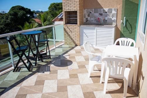 a patio with a table and chairs on a balcony at Luxo com Spa exclusivo no paraíso do Peró! in Cabo Frio