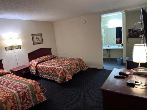 ein Hotelzimmer mit 2 Betten und einem Schreibtisch in der Unterkunft CRYSTAL MOTEL in Tulsa