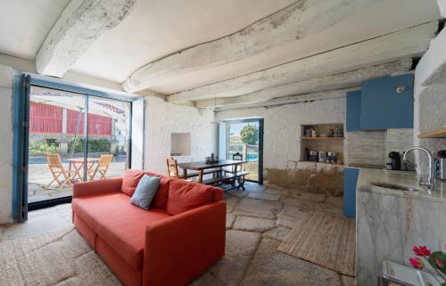 a living room with a red couch and a table at Casas de Vila Pouca in Mondim de Basto