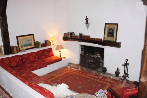 uma sala de estar com um sofá vermelho e uma lareira em Azoia Wind Mill em Azoia