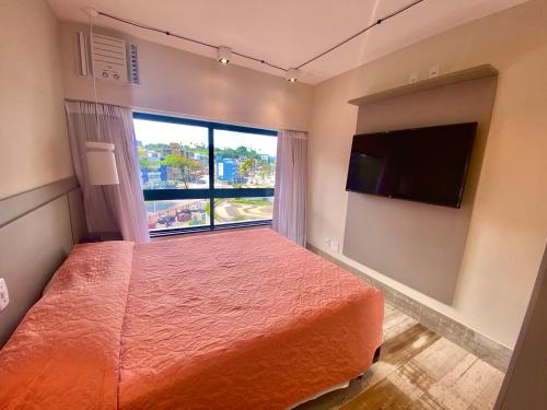 a bedroom with a large bed and a large window at Ondina Apart Hotel Residences in Salvador