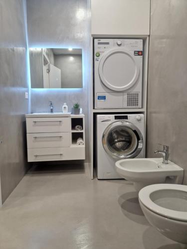 uma casa de banho com uma máquina de lavar roupa e um lavatório em Deluxe Rent Apartment em Tirana